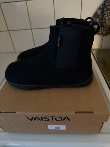 Asiakkaan mustat Vaistoa Sulo -paljasjalkanilkkurit kenkälaatikkonsa päällä.