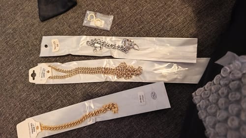 Reviewer's gold and silver Miami Cuban chains laid out in their original packaging.