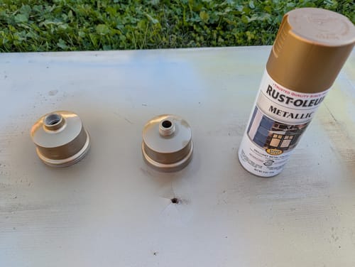 Customer spray painting the two pieces of the Shower Head Filter a metallic bronze color.