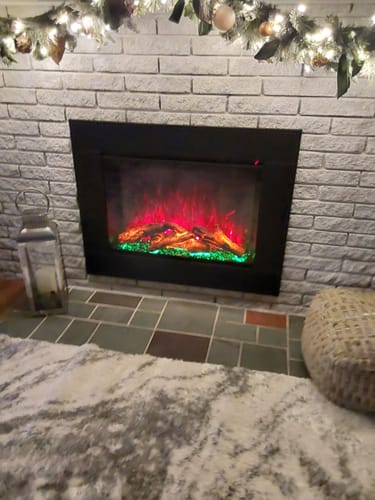 Customer's Modern Flames Redstone Firebox insert installed in a white brick fireplace with red and green flames.
