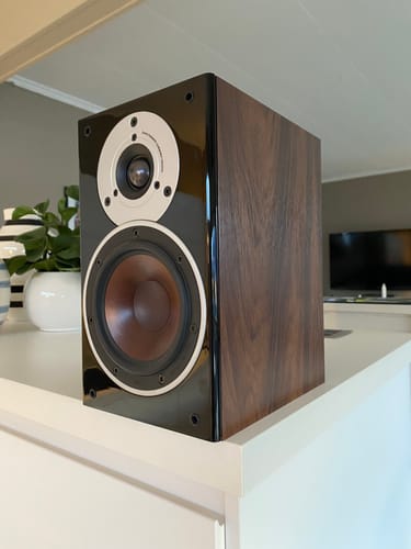 Nærbilde av anmelderens høyttaler med en blank, ny finish fra Walnut Deep kontaktplast.