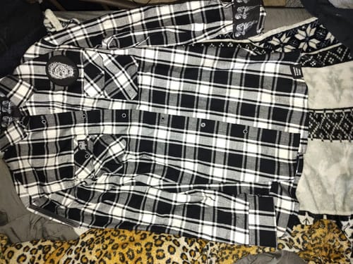 Reviewer's black and white plaid Death flannel shirt laid out flat, showing the chest patch and cuff designs.