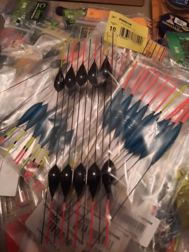 Klant toont een verzameling zwarte en blauwe KERRY dobbers in hun plastic verpakking.