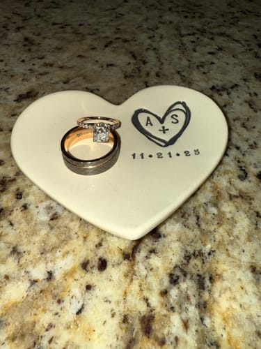 Customer's Gladiator ring placed with a diamond ring on a personalized, heart-shaped dish.
