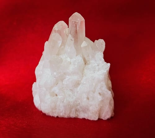 Customer's clear quartz crystal cluster from their VIP Crystal Club box shown on a red cloth.