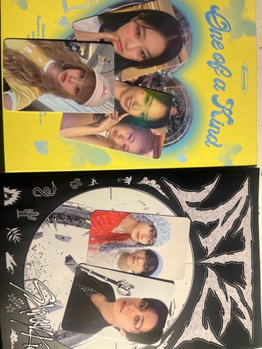 Customer's two albums from the KPOP MYSTERY ALBUM purchase, one black and white and one yellow, with several photo cards.