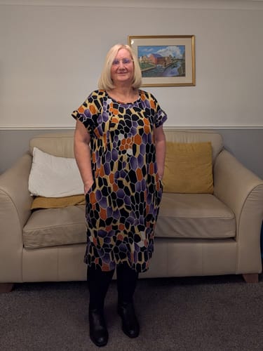 Reviewer wearing a short-sleeved dress with pockets, made from the colorful Modern Mosaic jersey fabric.