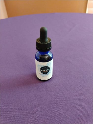 Customer's blue dropper bottle of Meraki Blu Methylene Blue sitting on a purple surface.