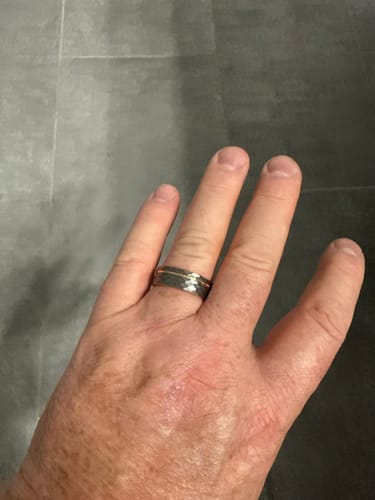 Customer's hand wearing the 8mm Gladiator Set ring, showing its dark hammered finish and thin center inlay.