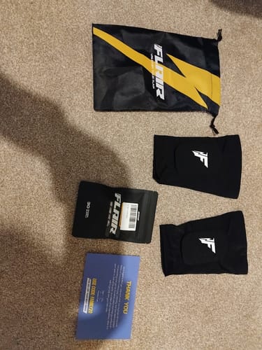 Customer's Built-In Shin Pads shown with the packaging and black carrying bag on a carpet.