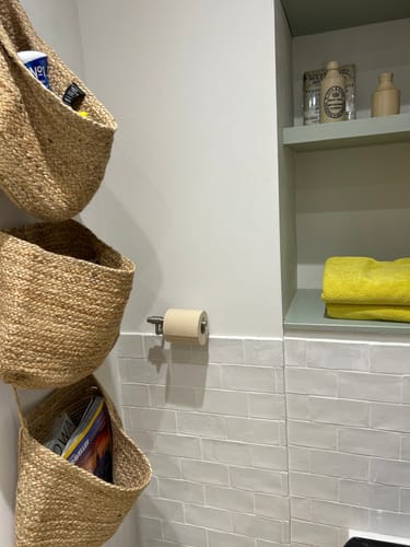 Customer's roll of unbleached bamboo toilet paper on a holder in a bathroom.
