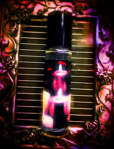 Customer's 'Fall in Love Whenever You Can' rollerball with a candle-art label, displayed in an ornate, dark rose frame.