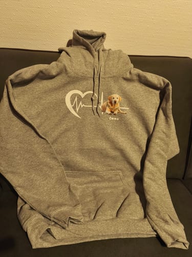 Kundenfoto eines personalisierten grauen Herzschlag-Hoodies mit einem Hundefoto und dem Namen 'Emma' auf der Brust.