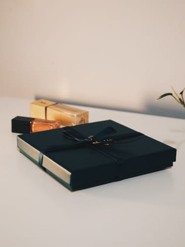 Customer's Discovery Set shown in its dark, elegant box tied with a ribbon.