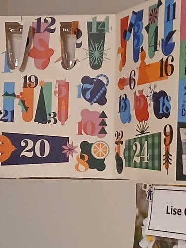 Customer's '24 Days of Bath and Body Bliss' advent calendar with colorful, numbered doors, some of which are open.
