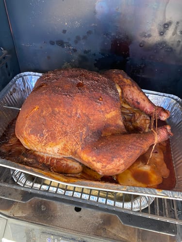 Customer's seasoned turkey cooking in a smoker after using the Turkey Brine Kit.