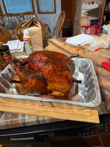 Customer's smoked turkey with a dark, golden-brown skin in an aluminum pan, prepared using the Turkey Brine Kit.