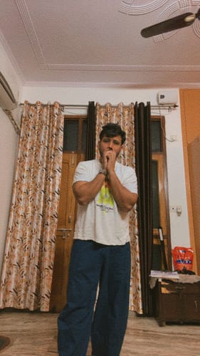 Customer standing indoors wearing blue, loose-fitting Boxate Yoga Pants.