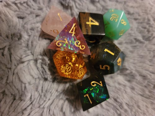Customer's colorful set of mismatched Mystery Dice from a blind bag, laid out on a fluffy surface.