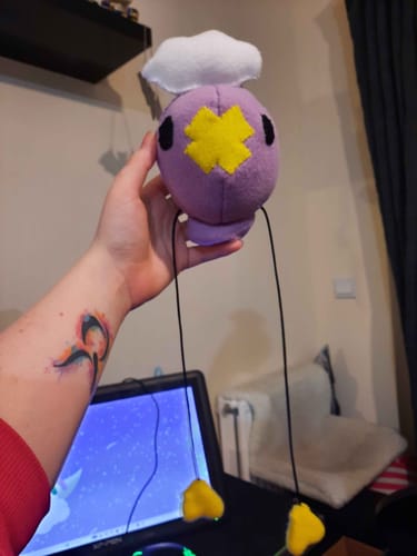 Customer holding a handmade purple plush toy made from the soft polar fleece fabric.