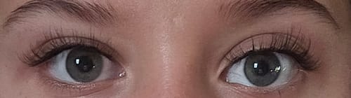 Reviewer showing a close-up of their eyes wearing the long, fanned-out Layered Doll Eye lashes.