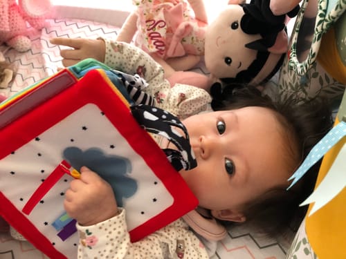 Customer's Personalized Princess Peony doll with black hair lying next to a baby.