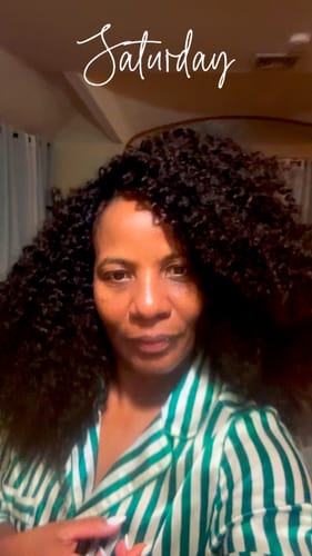 Customer wearing the voluminous, dark Water Curly Human Crochet Hair styled down indoors.