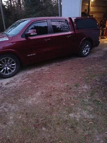 Customer's dark red Dodge Ram 1500 with a camper shell, showing the lowered suspension after installation.