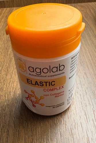 Recensore mostra il barattolo di integratori Elastic Complex con il suo coperchio arancione.