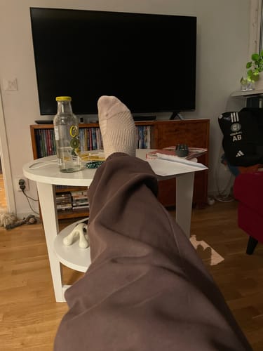 Kundens fot i en ljus Diasocks Stödstrumpa som vilar på ett bord.