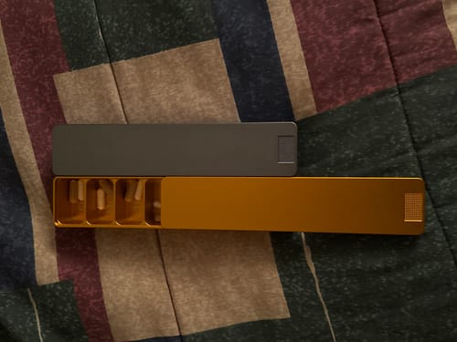 Reviewer's Weekly AM-PM Vitamin XL Case 2.0 shown separated, with the gold part open to reveal pills inside.