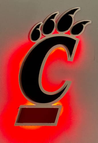 Customer's Cincinnati Bearcats wall art mounted on a wall and glowing with a bright red backlight.