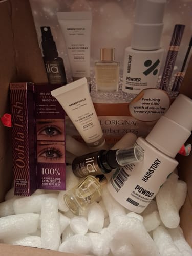 Customer unboxing The Monthly Beauty Box, showing included skincare, hair, and makeup products in the packaging.