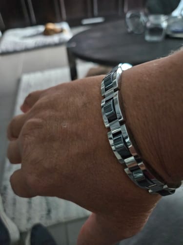 A close-up of a reviewer wearing the Bradley Battletrack Bracelet, showing the silver-tone and black links on their wrist.