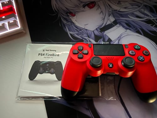 レビュー投稿者の赤いPS4 FireBirdコントローラーと、アニメキャラクターのデスクマット上の説明書。
