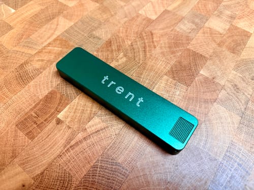 Customer's personalized green Weekly Case shown on a wood block counter.