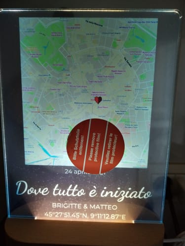 Ein Kunde zeigt das beleuchtete personalisierte Nachtlicht mit Karte und Text, noch mit der Schutzfolie.