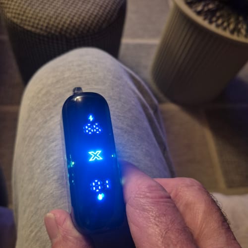 Customer holding the RandM Tornado 25000 vape, showing the bright blue illuminated display screen.