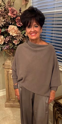 Customer wearing the mink Asymmetric Draped Seamless Knit, showing its relaxed drape and fitted sleeves.