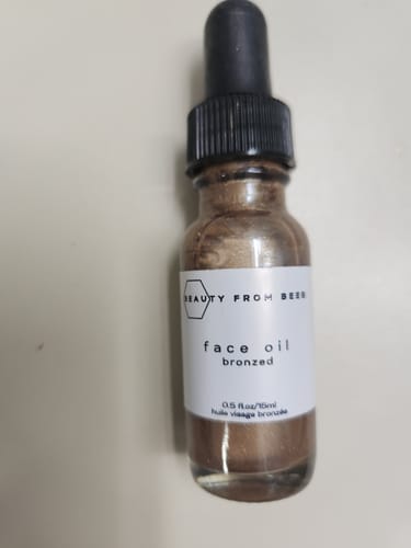 Customer's bottle of Bronzed Face Oil, showing the shimmery bronze liquid inside.