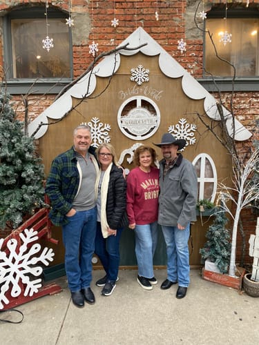 Reviewer wearing the red Making Spirits Bright Ribbed Crewneck in a group photo at a Christmas event.