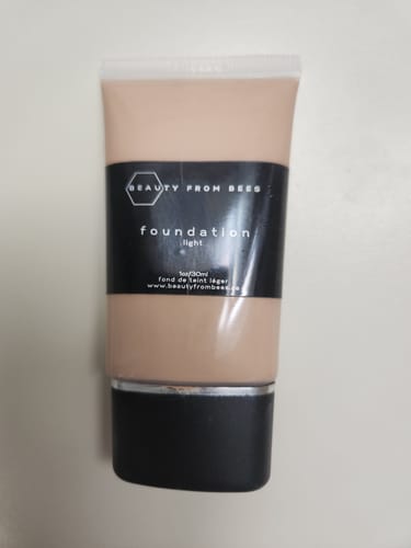 Customer's tube of Foundation in the shade 'light', a light-beige color shown in a clear tube with a black label.