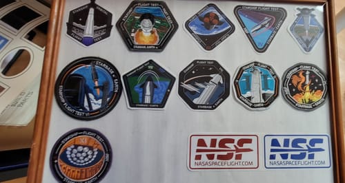Close-up of a customer's framed collection of Starship patches and two NSF Starship stickers.