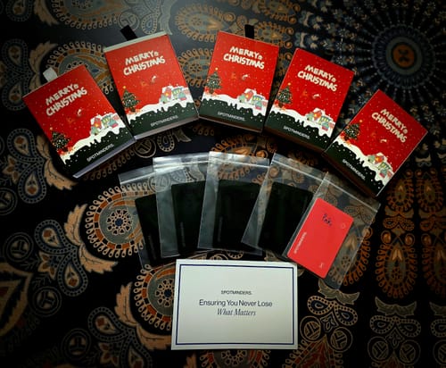 Customer's SPOTMINDERS Tracking Cards laid out with their festive Christmas-themed gift packaging.