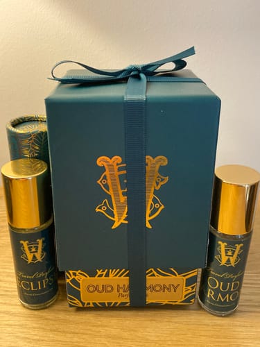 Customer's Oud Harmony fragrance shown in its decorative teal gift box alongside smaller travel-sized bottles.