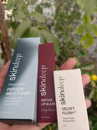 Customer holding the box for DREAM GLAZE Peptide Milk Toner with two other Skindeep products in their hand.