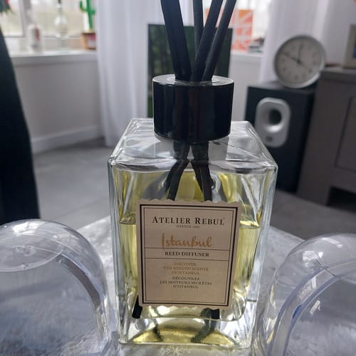 Klant toont de Istanbul Geurstokjes in een glazen fles met zwarte stokjes in de woonkamer.