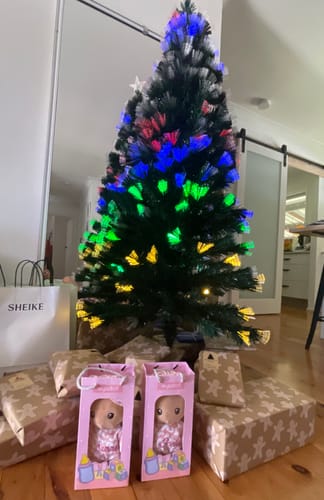 Reviewer's two Personalized Pudding Baby Girl dolls in pink boxes, placed with gifts under a decorated Christmas tree.