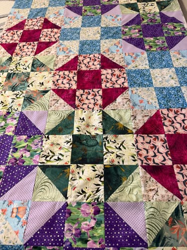 Customer's patchwork quilt made with the Winter Owl on Branch Fabric and other colorful fabrics.