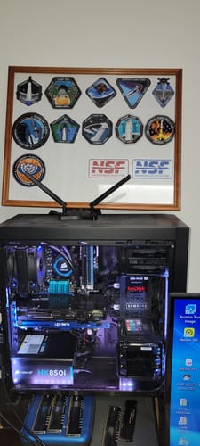 Customer's Starship Patch stickers displayed in a nice wooden frame above their computer setup.